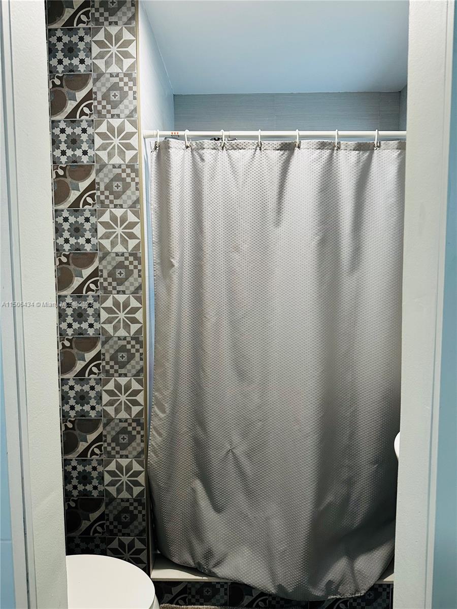 26232 Southwest 124th Place Homestead, FL 33032 - Photo 12 of 33 a bathroom with a shower curtain and sink