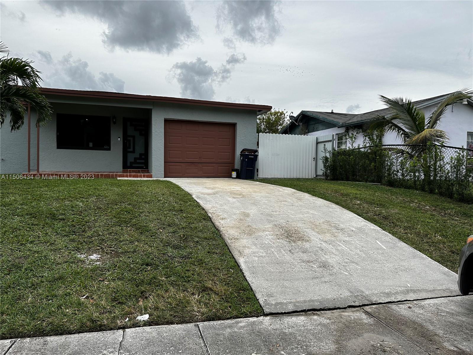 26232 Southwest 124th Place Homestead, FL 33032 - Photo 3 of 33 a front view of a house with a yard and garage