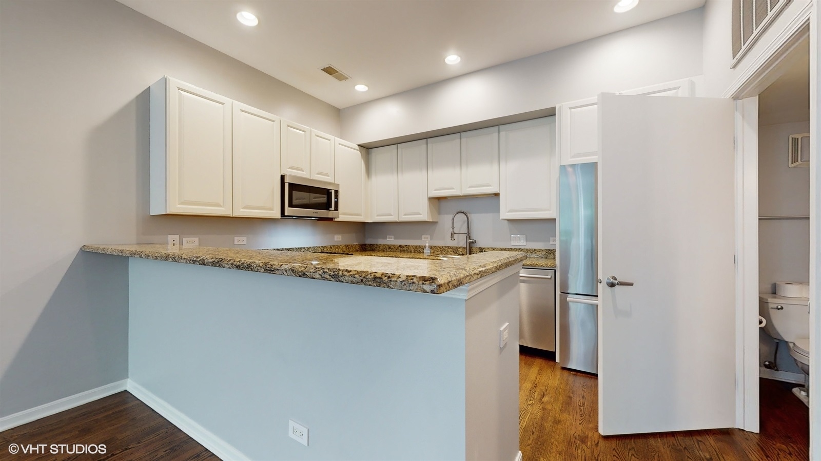 915 North Howe Street Chicago, IL 60610 - Photo 7 of 30 a kitchen with granite countertop white cabinets and stainless steel appliances