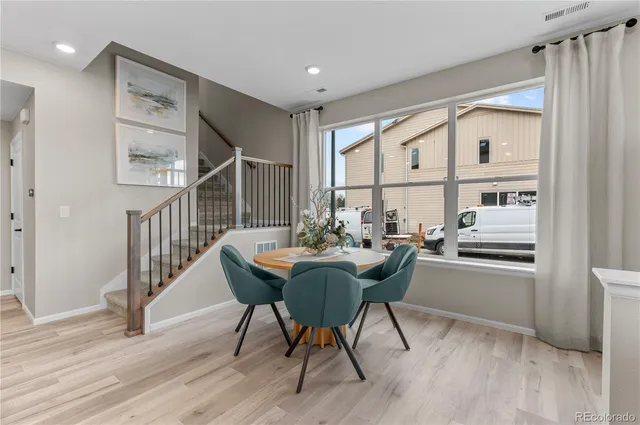 a dining room with furniture window and wooden floor