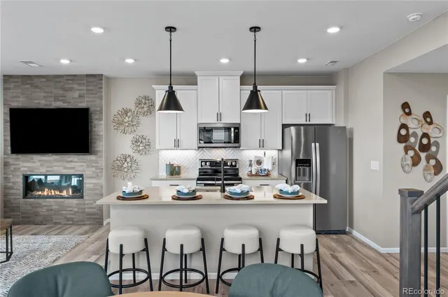 a kitchen with stainless steel appliances kitchen island granite countertop a sink refrigerator and cabinets