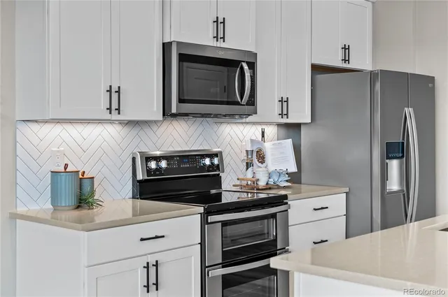 a kitchen with stainless steel appliances a stove microwave and refrigerator