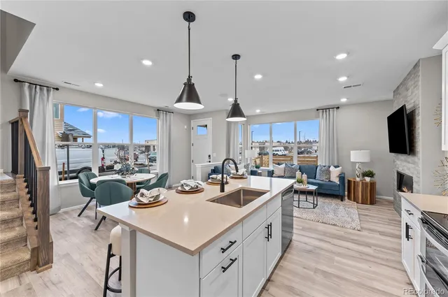 a kitchen with a sink dishwasher a stove and a refrigerator with wooden floor