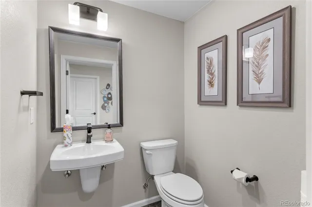 a bathroom with a toilet a sink and mirror