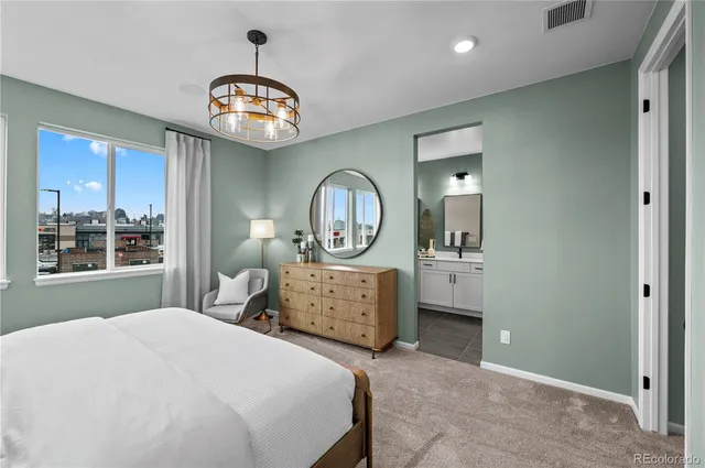 a bedroom with a bed a mirror and a window