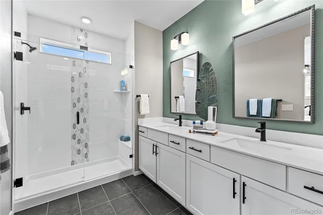 a bathroom with a double vanity sink mirror and shower