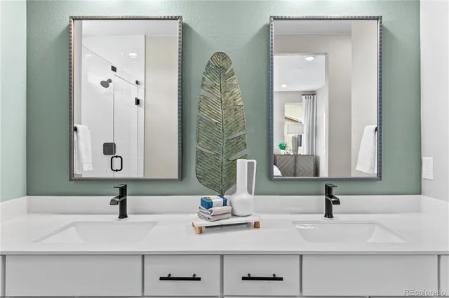 a bathroom with double vanity sinks and a mirror