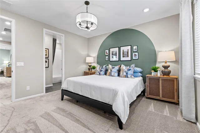 a spacious bedroom with a bed and a chandelier