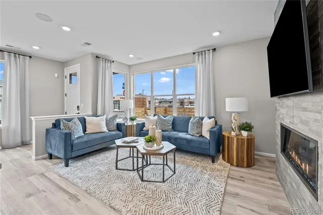 a living room with furniture a fireplace and a flat screen tv