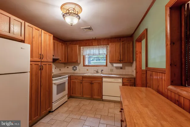 a kitchen with granite countertop stainless steel appliances a stove a sink a refrigerator and a window