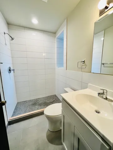 a bathroom with a sink a toilet a mirror and shower