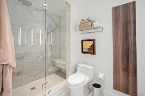 a bed sitting in front of a window and a chair