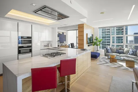 a kitchen with stainless steel appliances granite countertop a stove a refrigerator a dining table and chairs