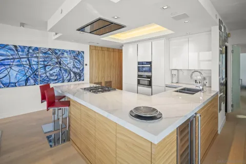 a kitchen with a sink a stove and chairs