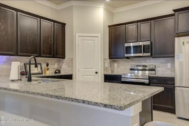 a kitchen with granite countertop a sink and a stove top oven with wooden floor