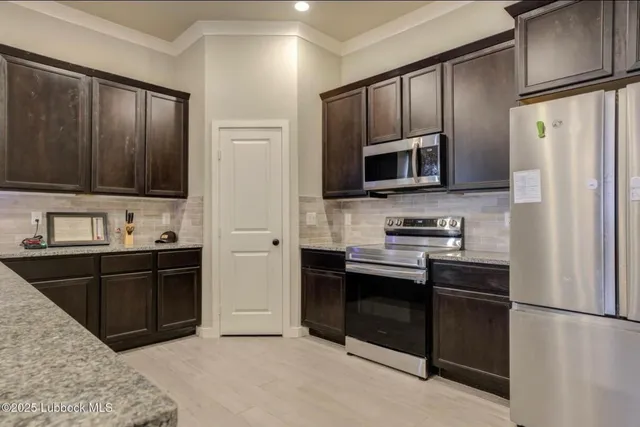 a kitchen with stainless steel appliances granite countertop a refrigerator stove and sink