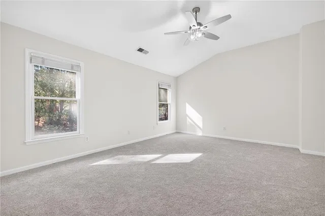 an empty room with windows and fan