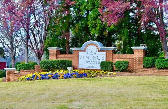 a front view of a house with a yard and potted plants