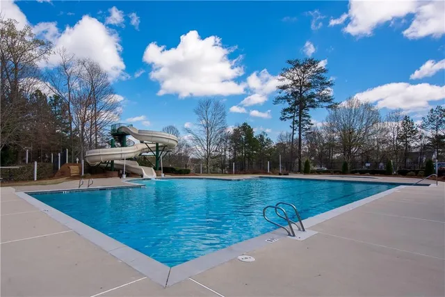 a view of a swimming pool and trees in the background
