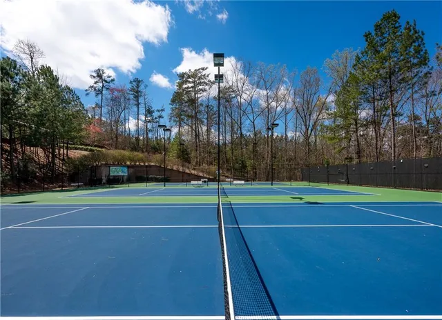 a view of a patio with table and chairs potted plants and large tree