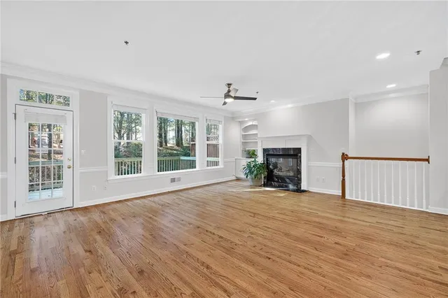 a view of empty room with wooden floor and fireplace