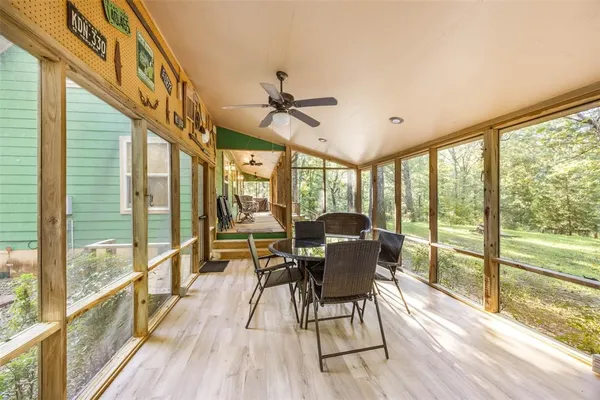 a view of a dining room with furniture a chandelier and wooden floor