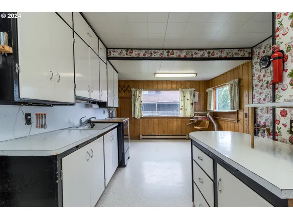 a kitchen with stainless steel appliances granite countertop a sink a stove and a wooden floors