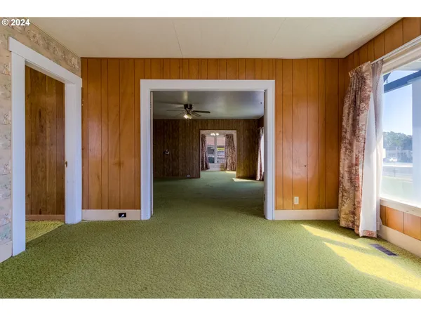 a view of an empty room with closet and a window