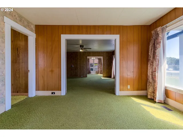a view of an empty room with closet and a window
