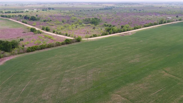 an aerial view of field with ocean view
