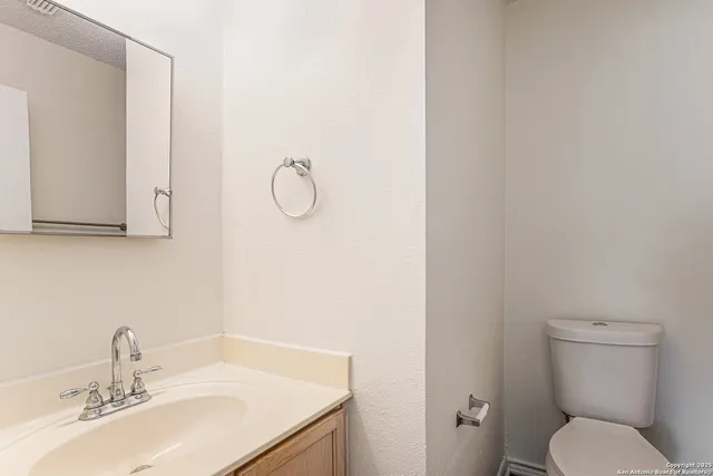 a bathroom with a toilet sink and mirror
