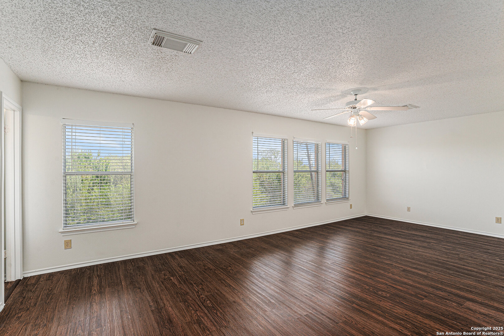 8447 Mannington Place Converse, TX 78109 - Photo 15 of 26 a view of an empty room with wooden floor and a window