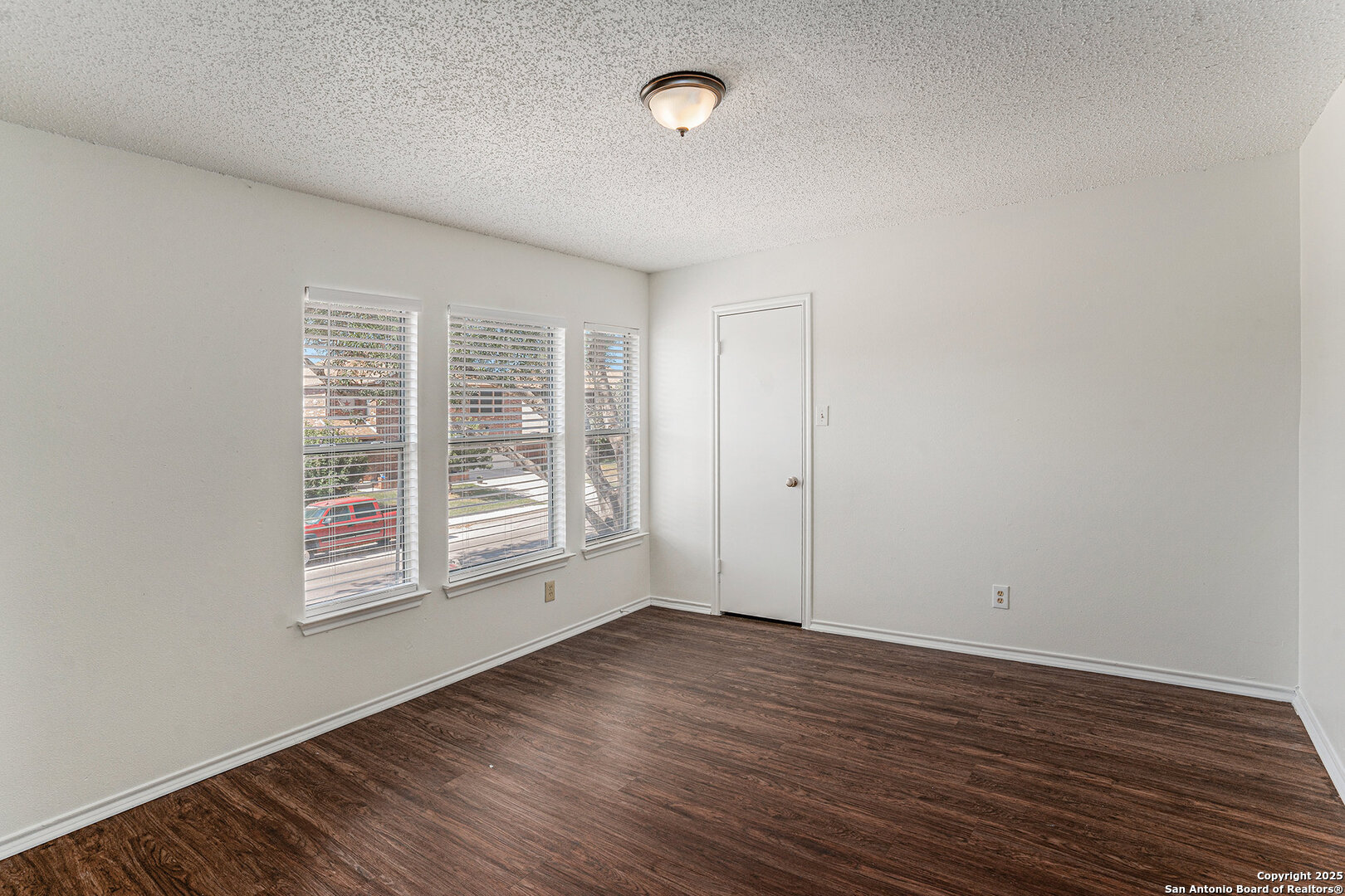 8447 Mannington Place Converse, TX 78109 - Photo 18 of 26 an empty room with wooden floor and windows