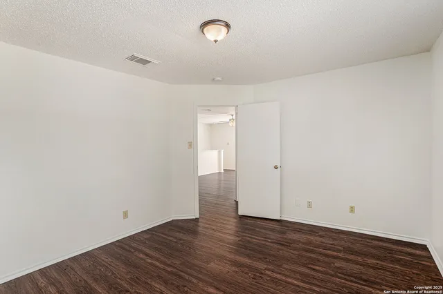 a view of a room with wooden floor and white walls