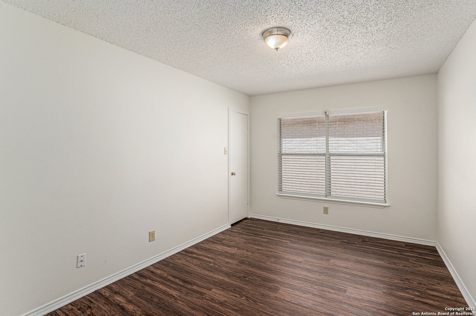 8447 Mannington Place Converse, TX 78109 - Photo 21 of 26 an empty room with wooden floor and windows