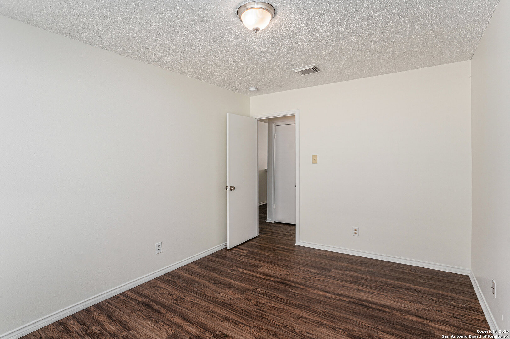 8447 Mannington Place Converse, TX 78109 - Photo 22 of 26 a view of a room with wooden floor and white walls