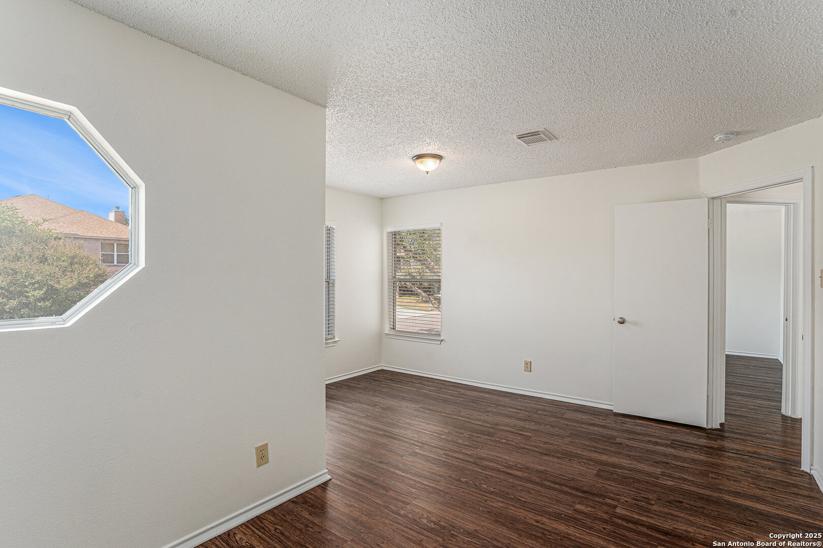 8447 Mannington Place Converse, TX 78109 - Photo 23 of 26 a view of an empty room with wooden floor and a window
