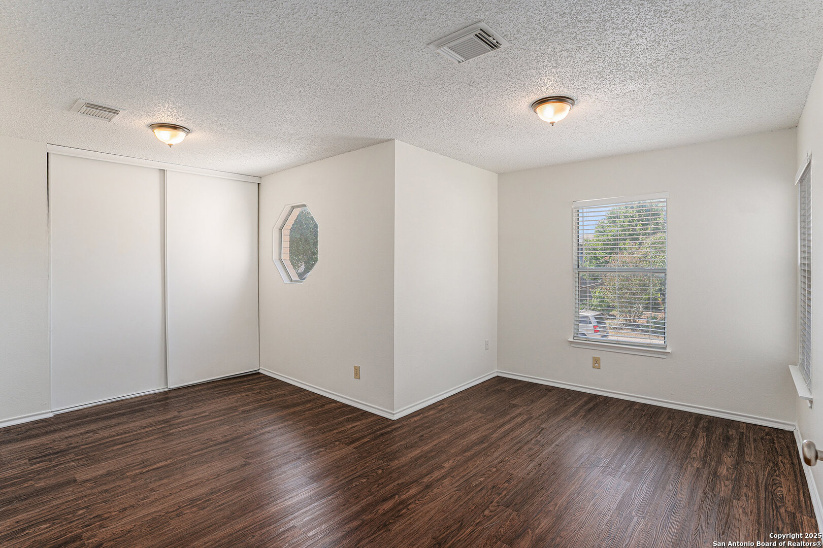 8447 Mannington Place Converse, TX 78109 - Photo 24 of 26 an empty room with wooden floor and windows