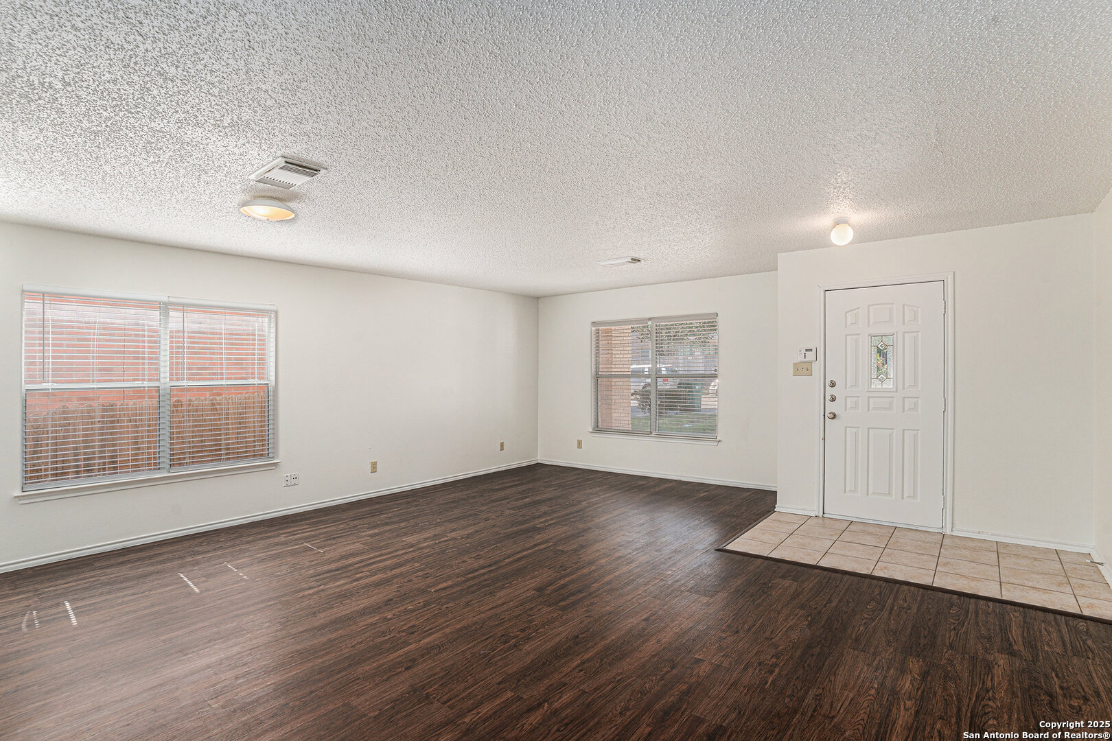 8447 Mannington Place Converse, TX 78109 - Photo 3 of 26 an empty room with wooden floor and windows
