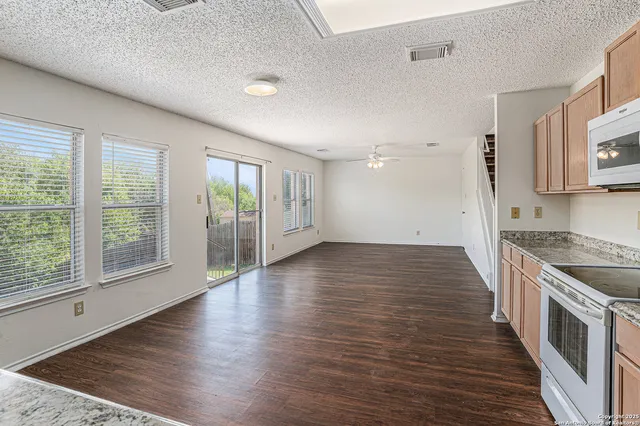 a view of a kitchen with wooden floor and a window