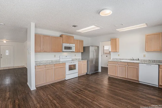 a kitchen with granite countertop white cabinets and stainless steel appliances