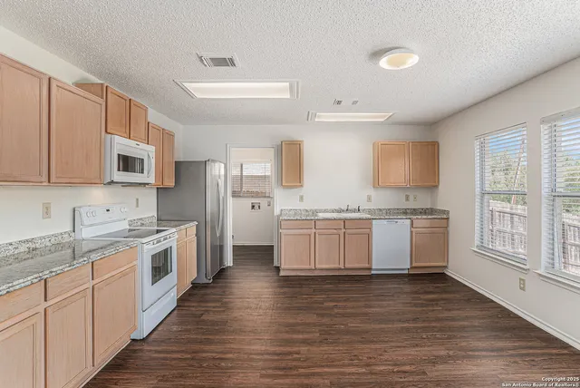 a large kitchen with a stove top oven and white cabinets