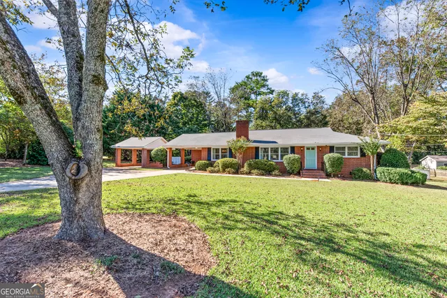 a front view of a house with yard and green space