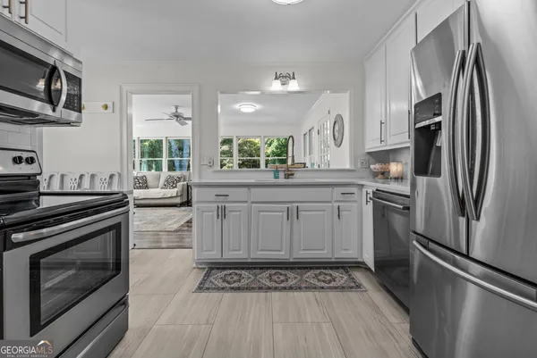 a kitchen with stainless steel appliances kitchen island a refrigerator sink and cabinets