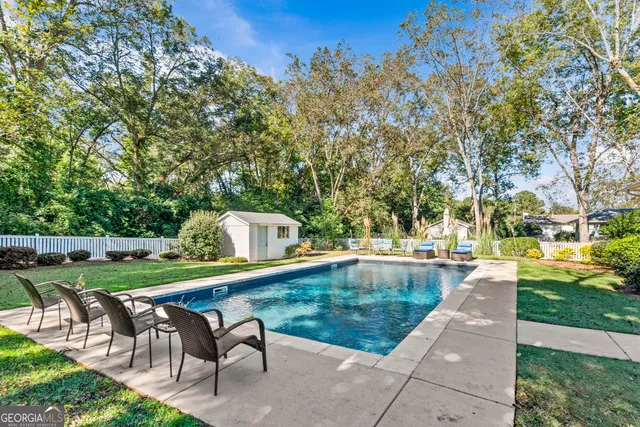 a view of a house with backyard and sitting area