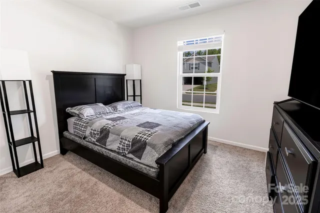 a bedroom with a bed flat screen tv and a window