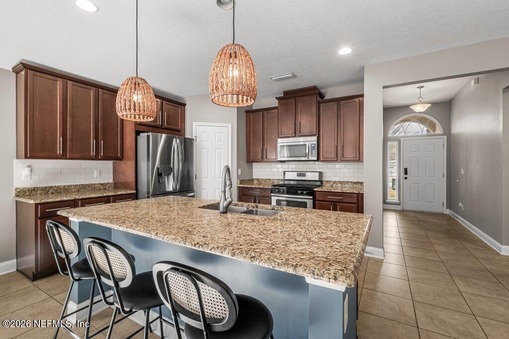 14042 Carson Court Jacksonville, FL 32224 - Photo 11 of 37 a kitchen with stainless steel appliances granite countertop a stove refrigerator and microwave