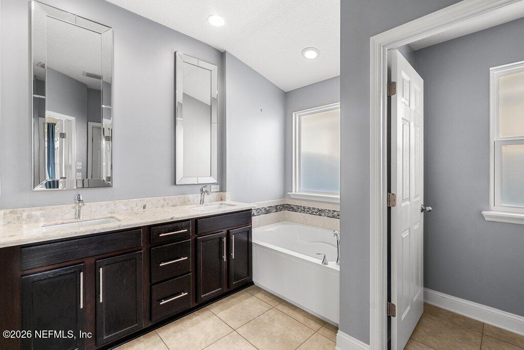 14042 Carson Court Jacksonville, FL 32224 - Photo 21 of 37 a spacious bathroom with a granite countertop double vanity sink a mirror and a bathtub