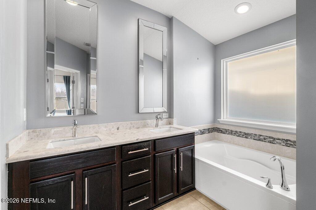 14042 Carson Court Jacksonville, FL 32224 - Photo 22 of 37 a bathroom with a tub a sink and mirror