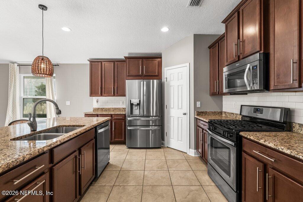 14042 Carson Court Jacksonville, FL 32224 - Photo 10 of 37 a kitchen with stainless steel appliances granite countertop a sink stove and refrigerator